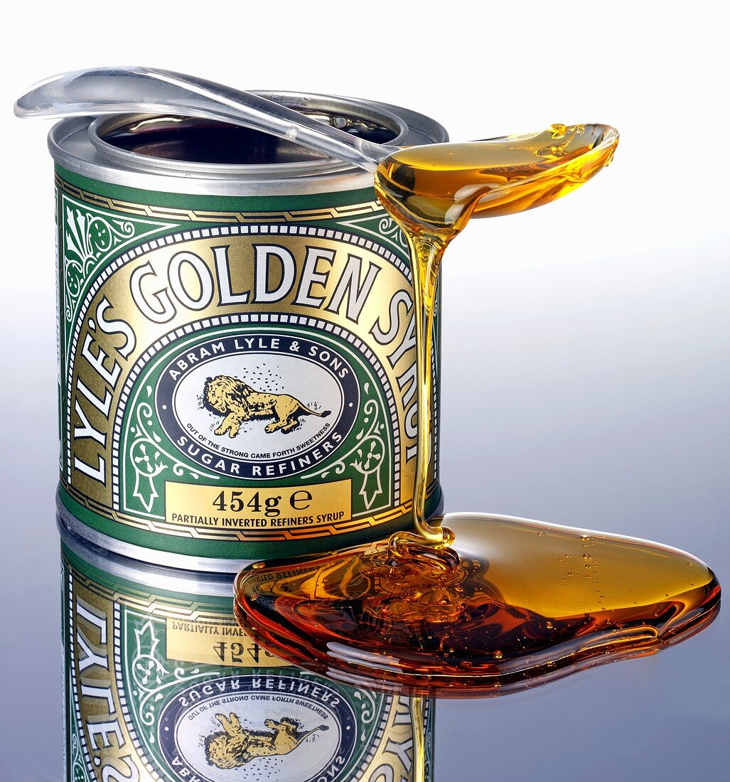 Golden syrup trickling off a spoon