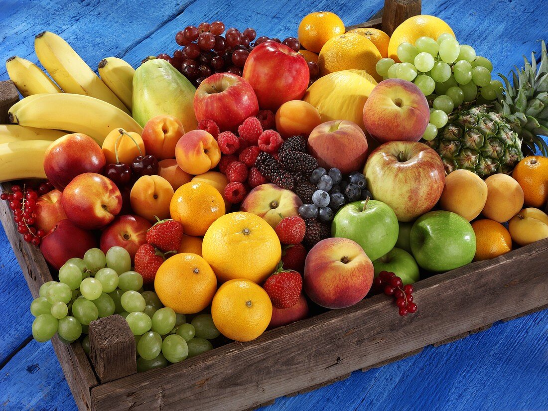 Frische Früchte und Beeren in Holzkiste