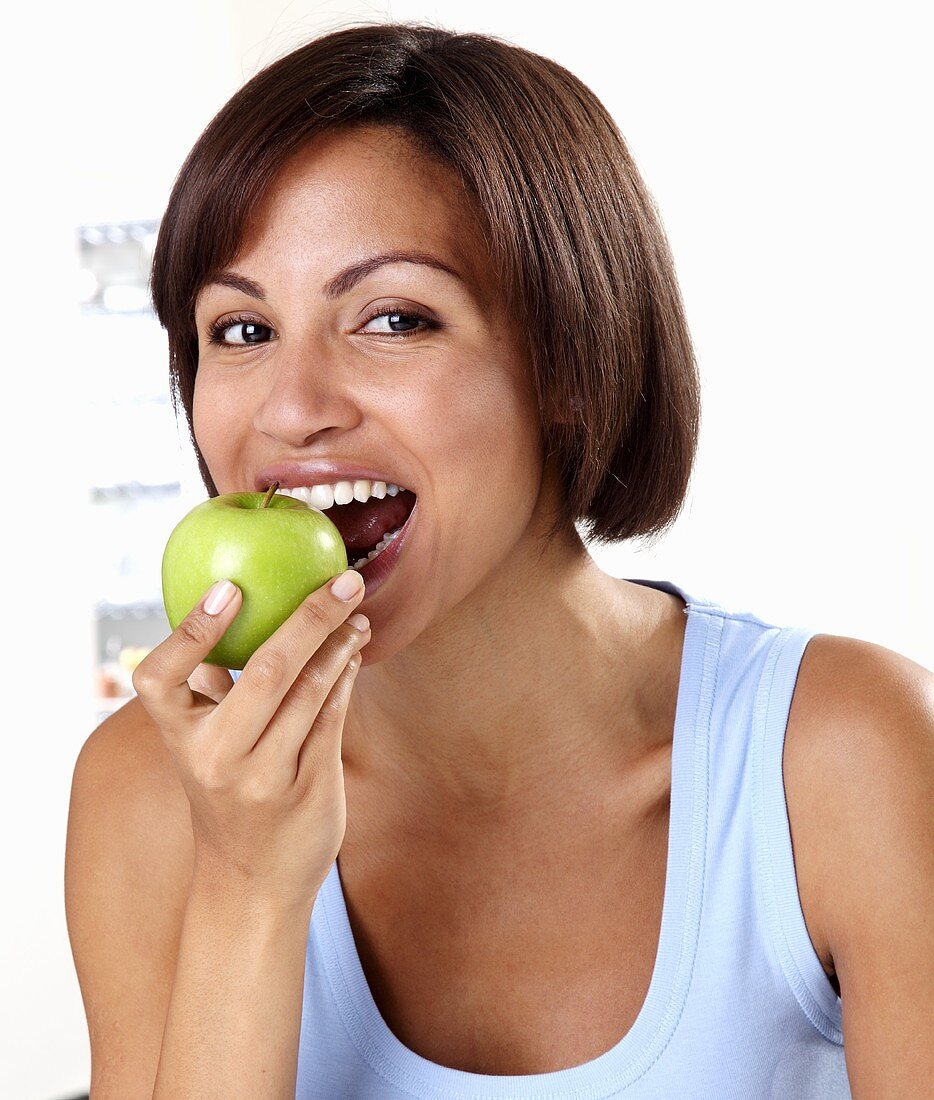 Frau isst grünen Apfel