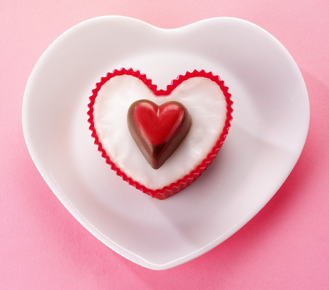 A heart-shaped fairy cake decorated with a heart-shaped praline