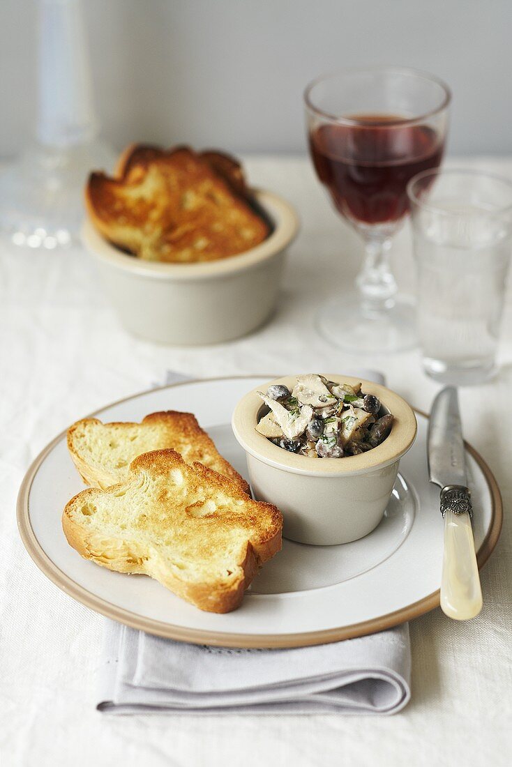 Herb mushrooms with toast and a glass of red wine