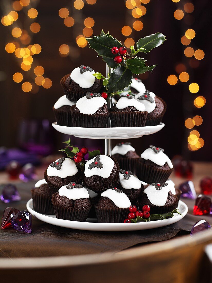 Christmas pudding muffins on a cake stand with holly