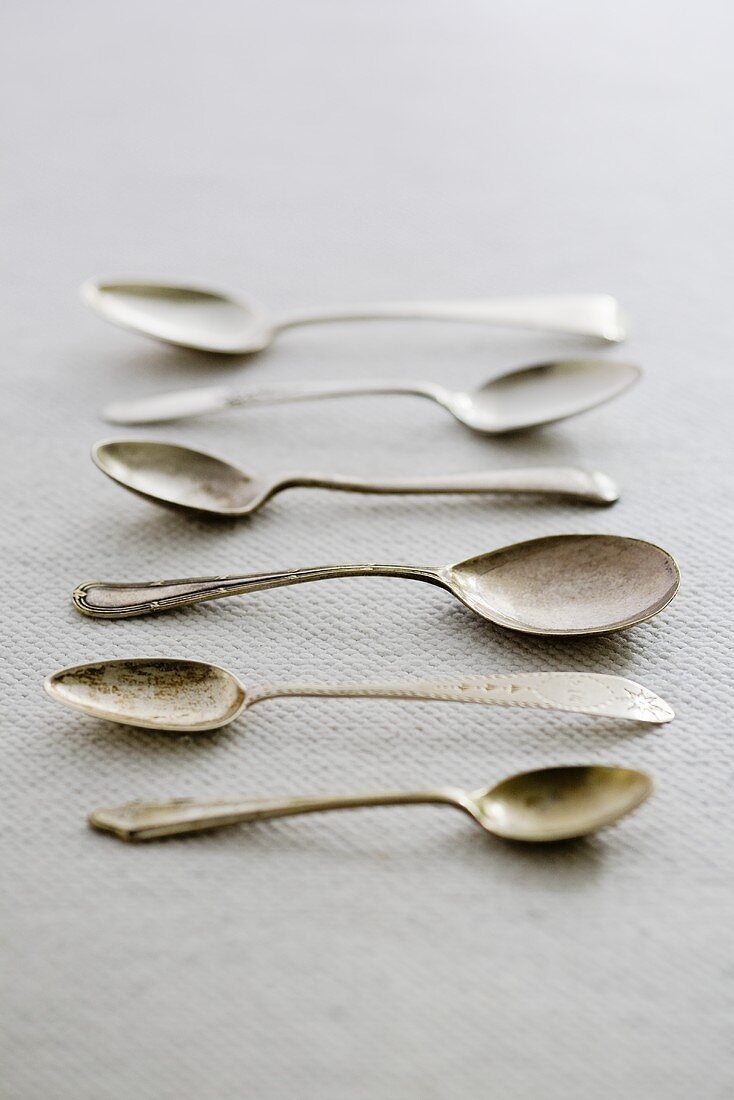 A row of antique silver spoons