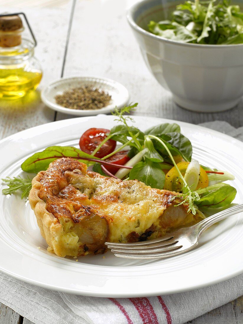 Tarte mit karamellisierten Schalotten und Honig, dazu Salat