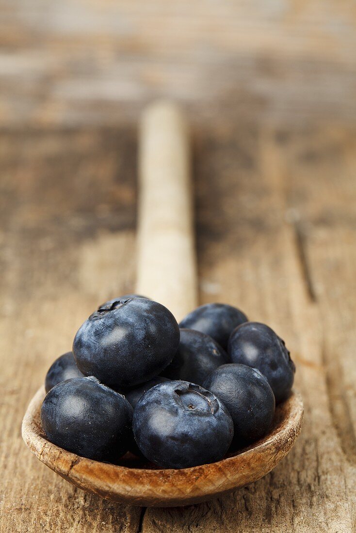 Blueberries on a wooden spoon (close-up)