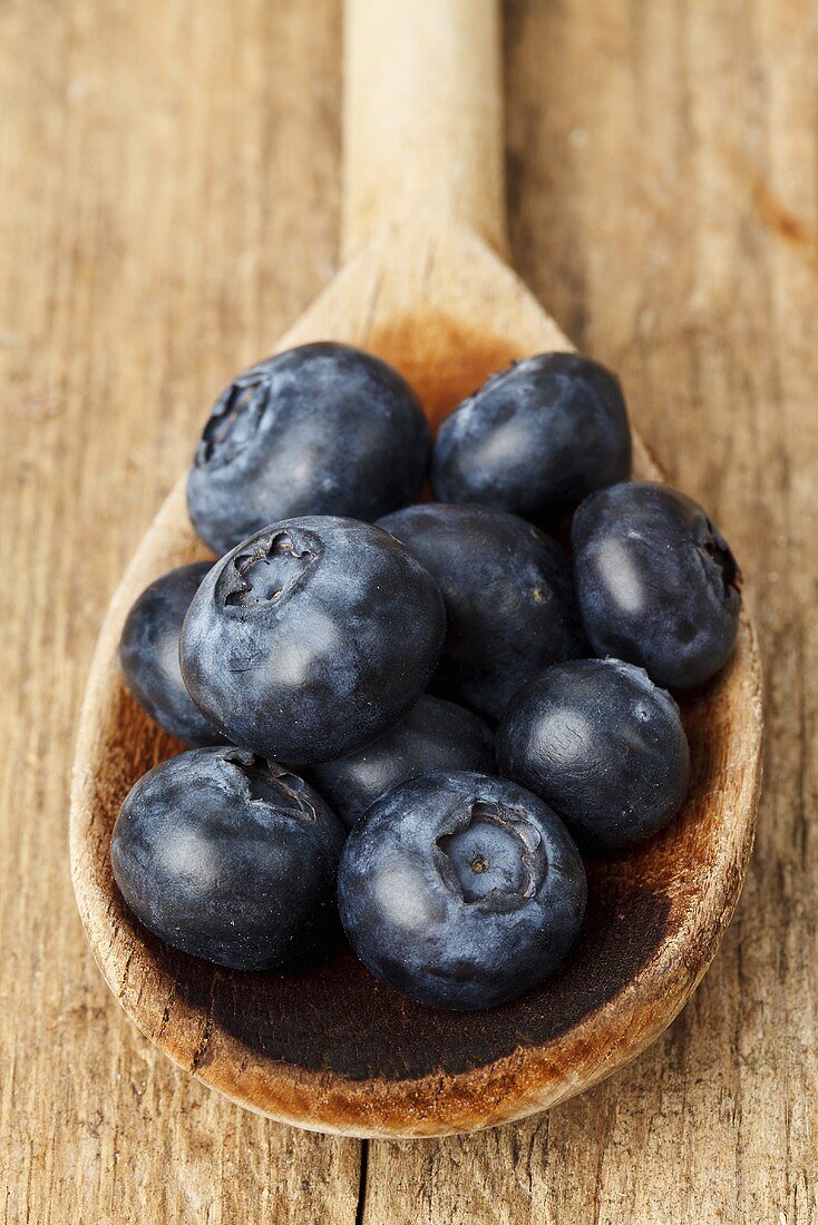 Blueberries on a wooden spoon see from above