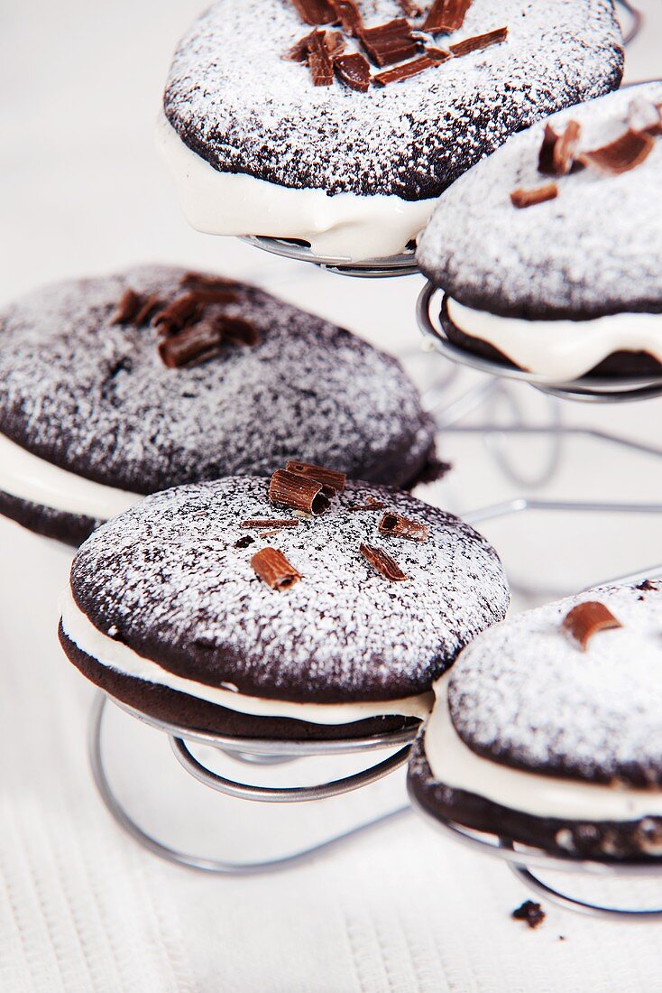 Mehrere Schokoladen-Whoopie Pies mit Puderzucker