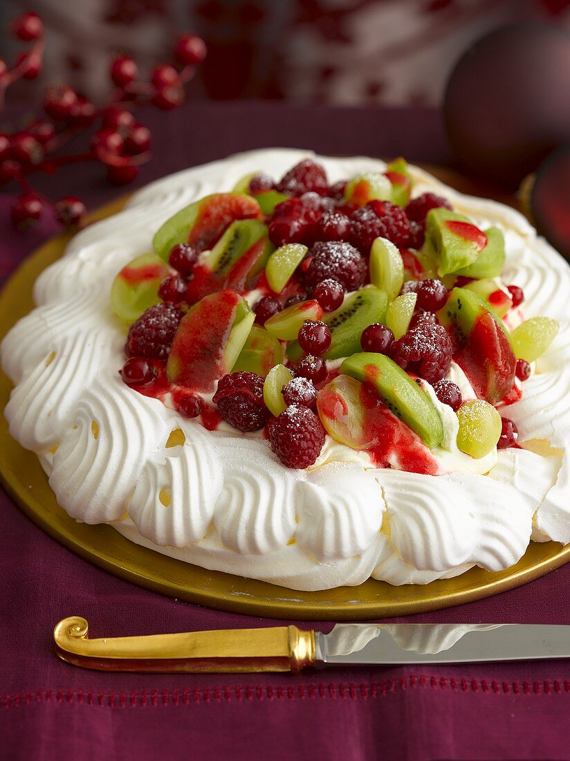 Pavlova mit Beeren und Kiwis zu Weihnachten