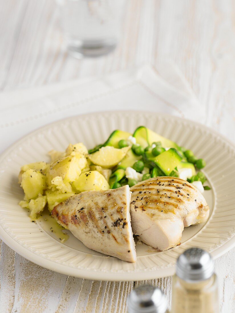 Grilled chicken breast with potatoes, peas and courgette