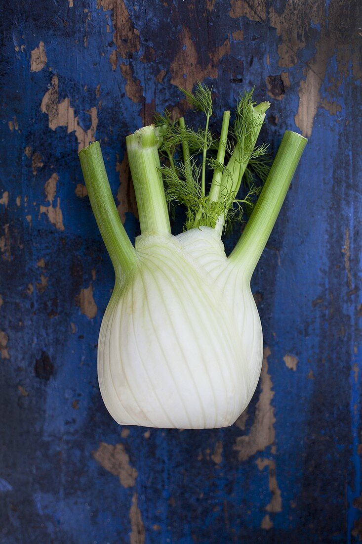 A fennel bulb on a worn, wooden surface