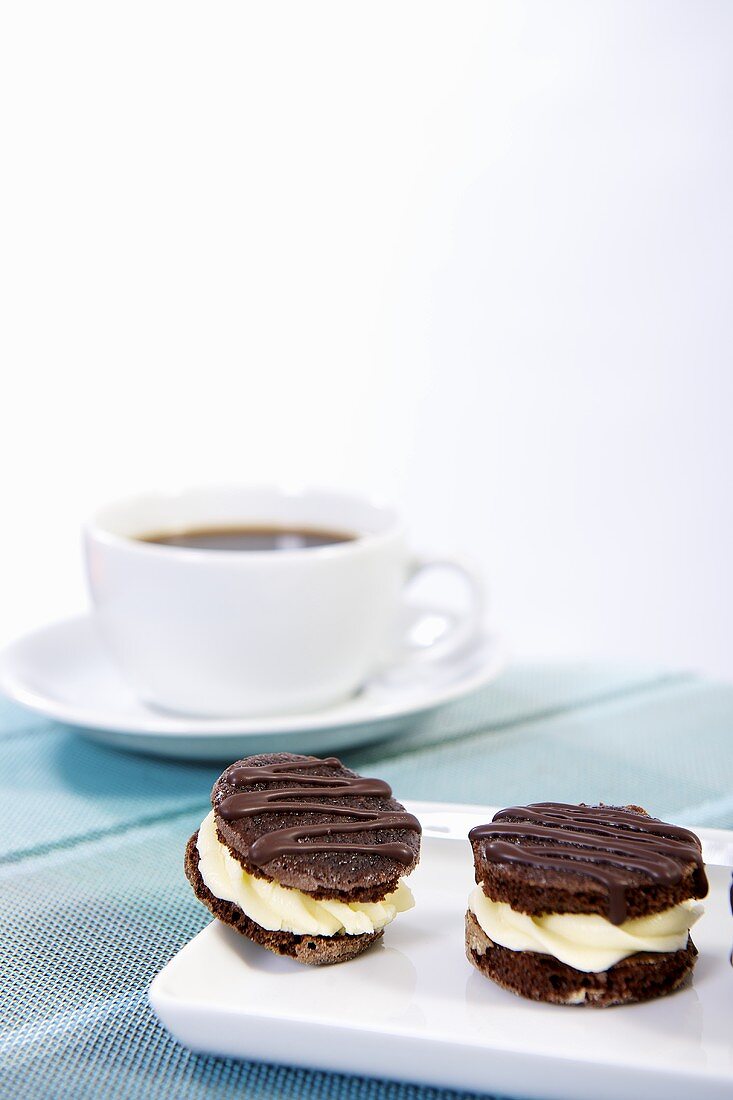 Chocolate biscuits filled with cream and a cup of coffee
