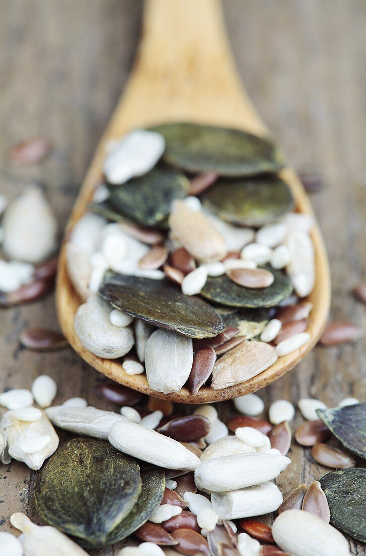 Mixed seeds on a wooden spoon