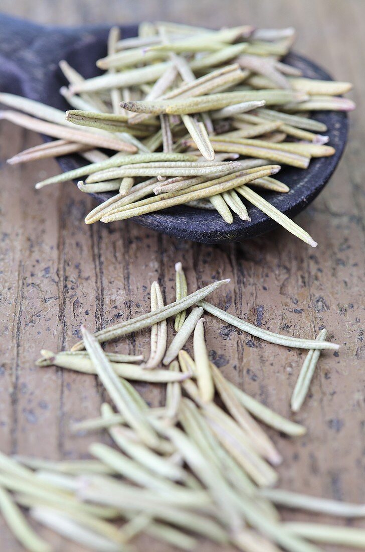 Dried rosemary needles with a wooden spoon