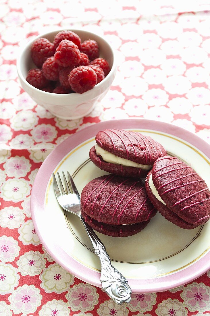 Himbeer-Whoopie Pies auf Teller mit Gabel, frische Himbeeren