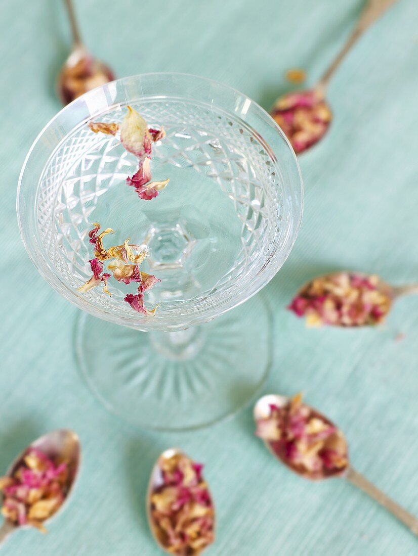 Rose water with dried rose petals in a glass dish