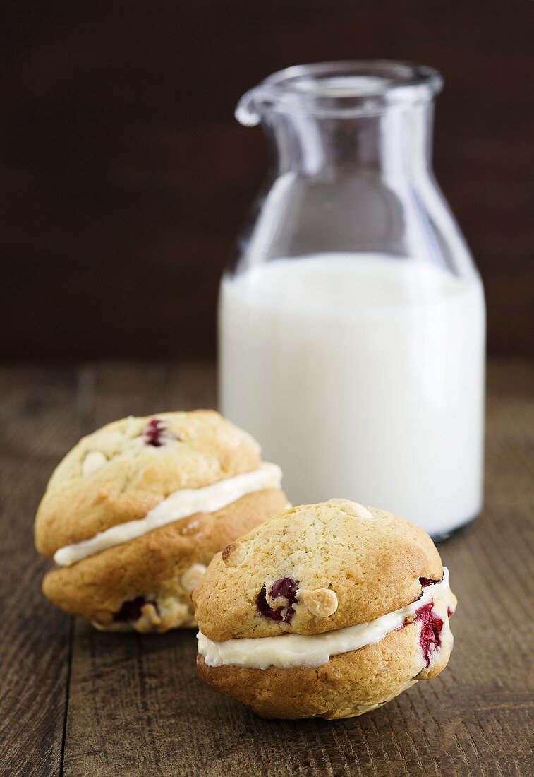 Cranberry-Whoopie Pies, gefüllt mit weisser Schokocreme, vor Milchflasche