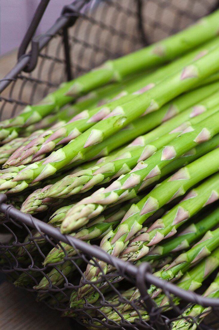 Fresh green asparagus stalks in a wire basket