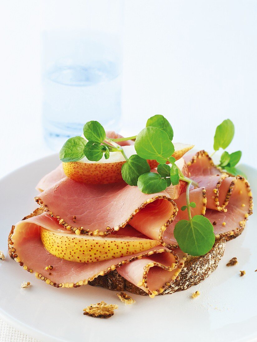 Bread topped with mustard ham, pears and water cress