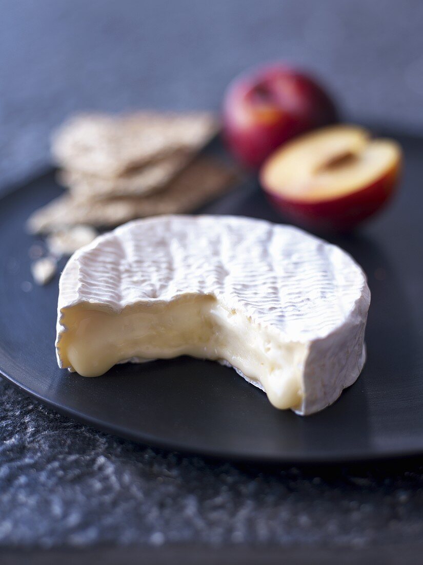 Camembert, crisp breads and plums