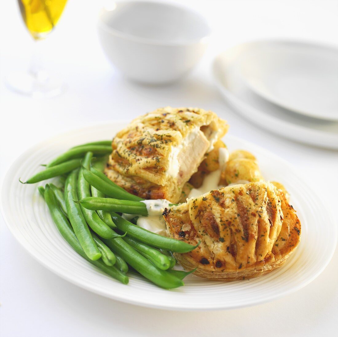 Chicken breast wrapped in puff pastry with garlic sauce and green beans