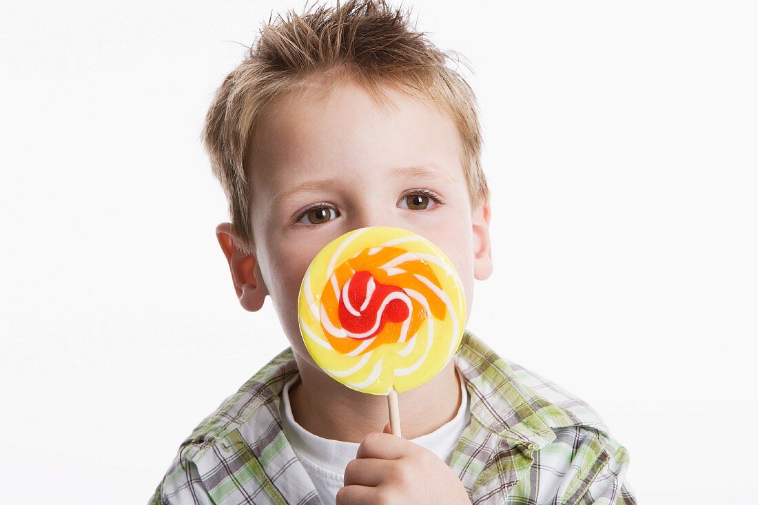 Boy holding large lollipop