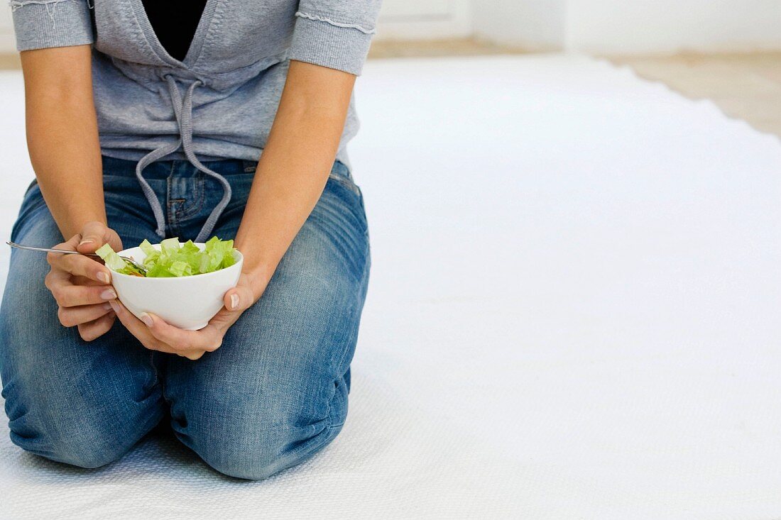 Woman holding a bowl of salad
