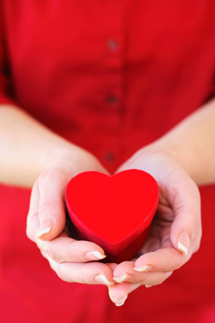 Hands holding heart shaped box