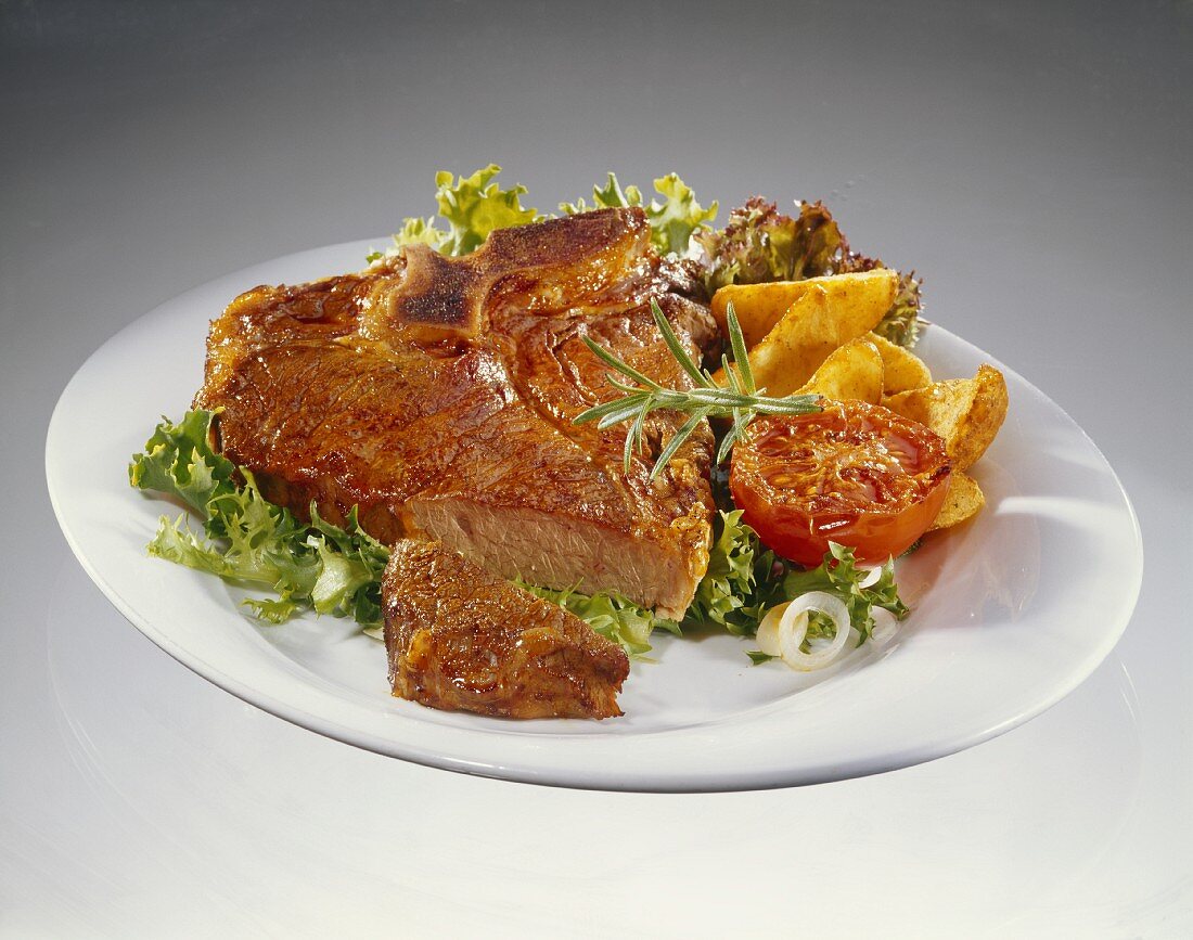 Fried T-bone steak on a bed of salad