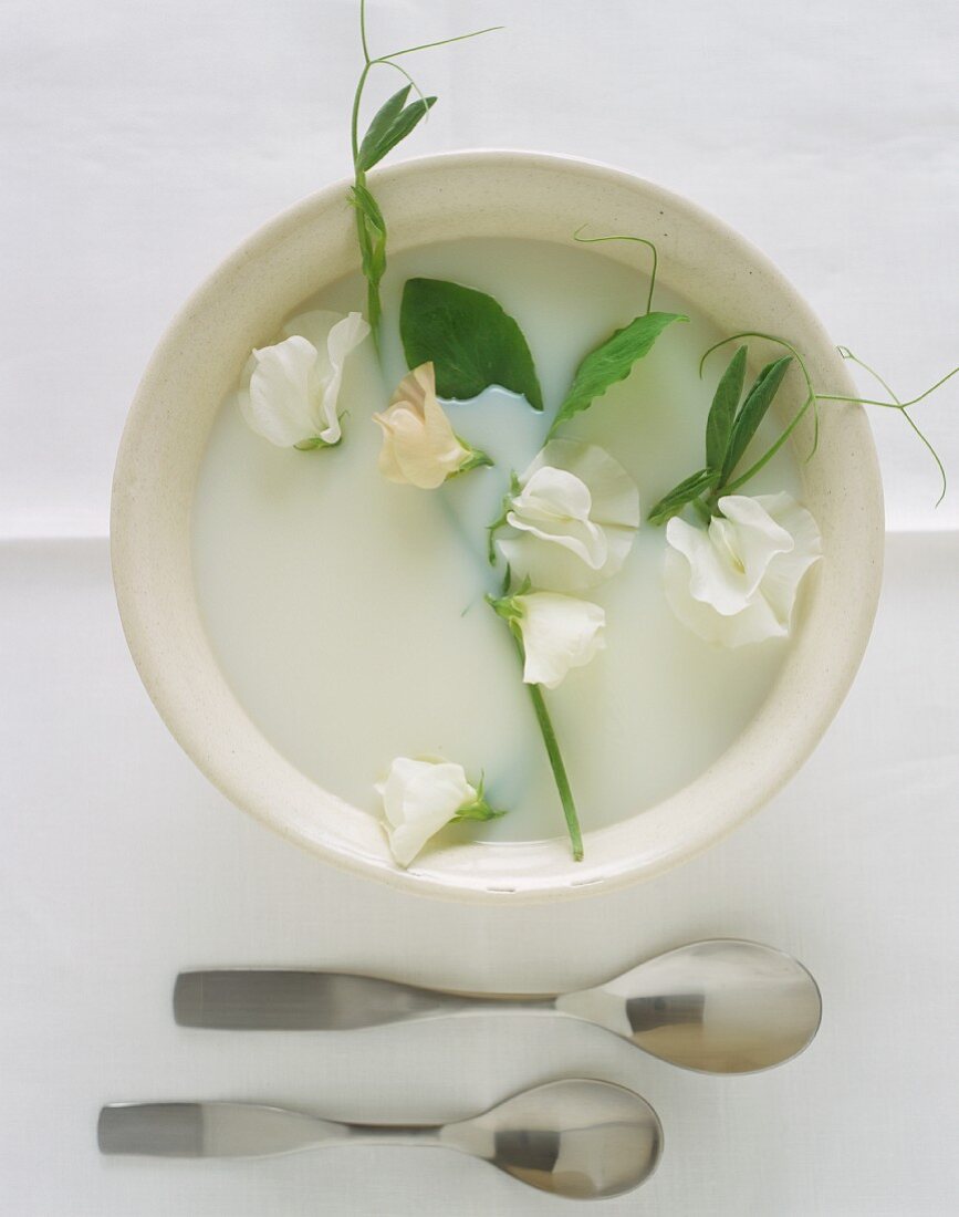 Vegane Kokosmilchsuppe mit Blüten dekoriert