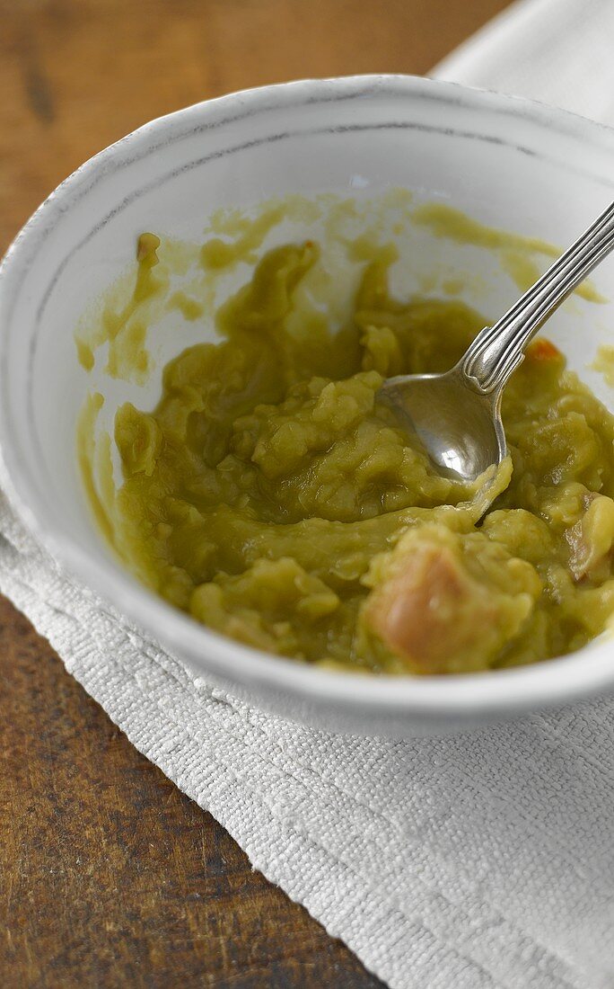 Leftover pea soup in a bowl with a spoon