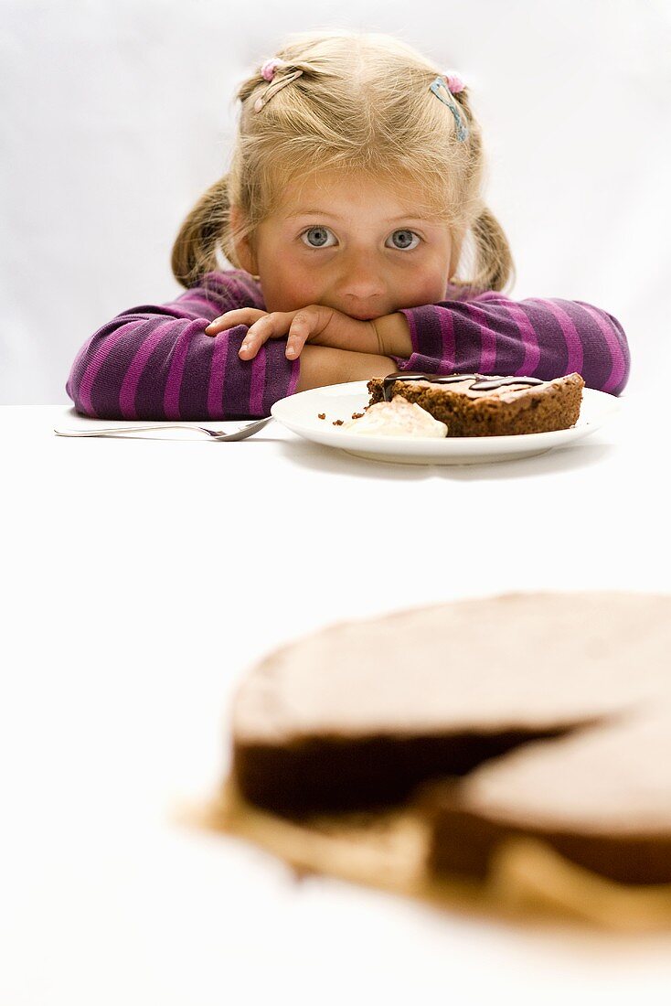 Kleines Mädchen isst Schokoladenkuchen