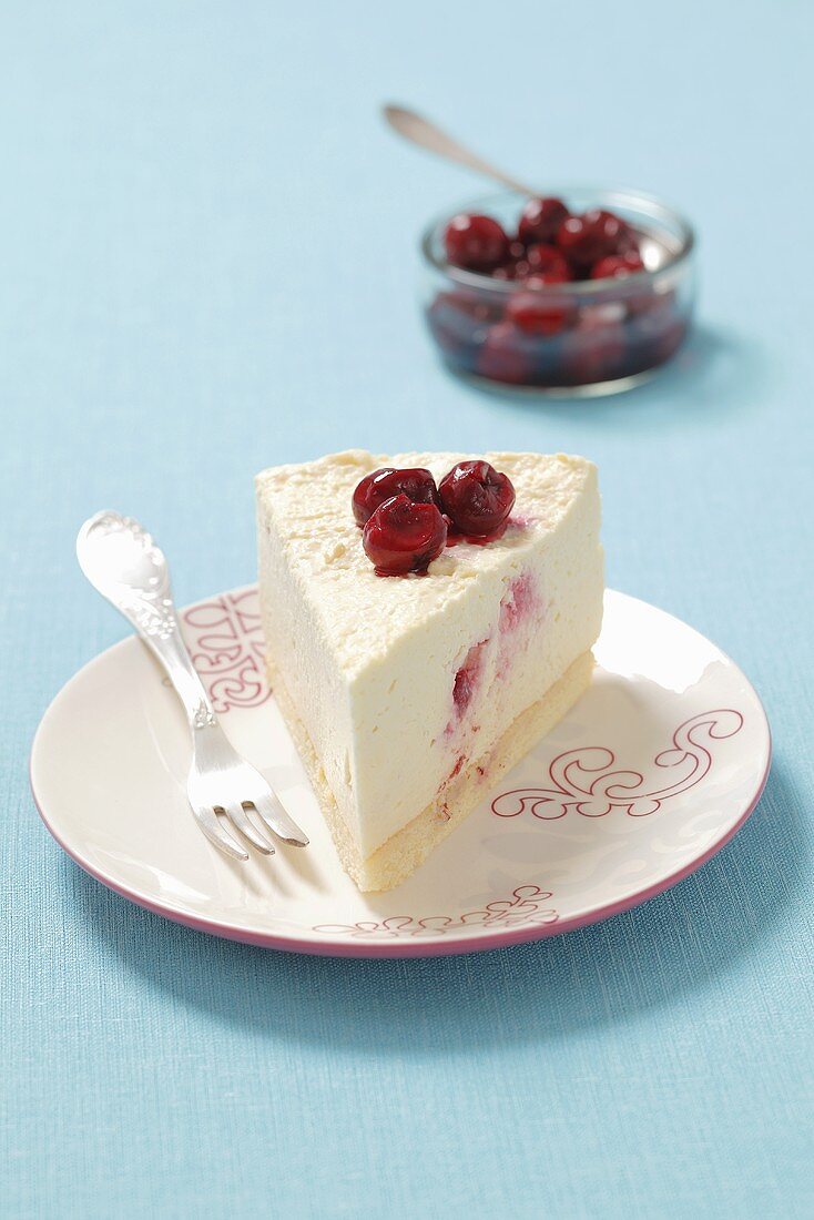 A slice of creamy cheesecake with sour cherries