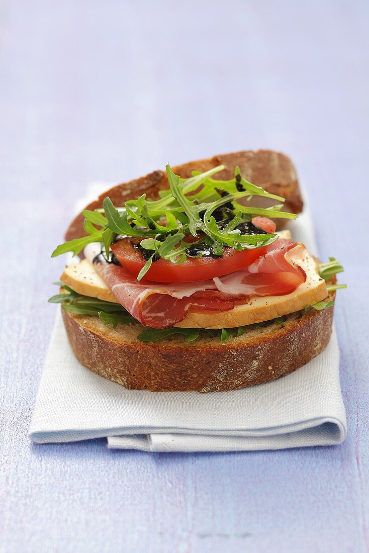 Vollkornbrot-Sandwich mit Räucherkäse, Schinken & Rucola