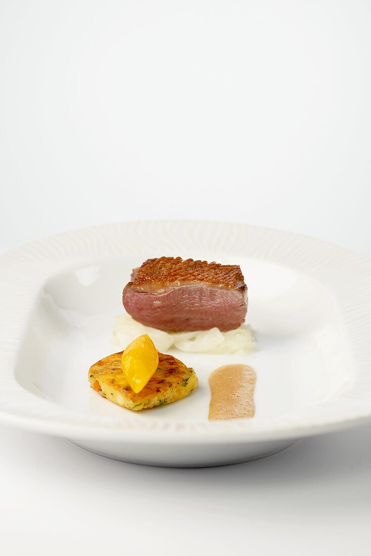 Pink duck breast with mustard sauce and potato roulade