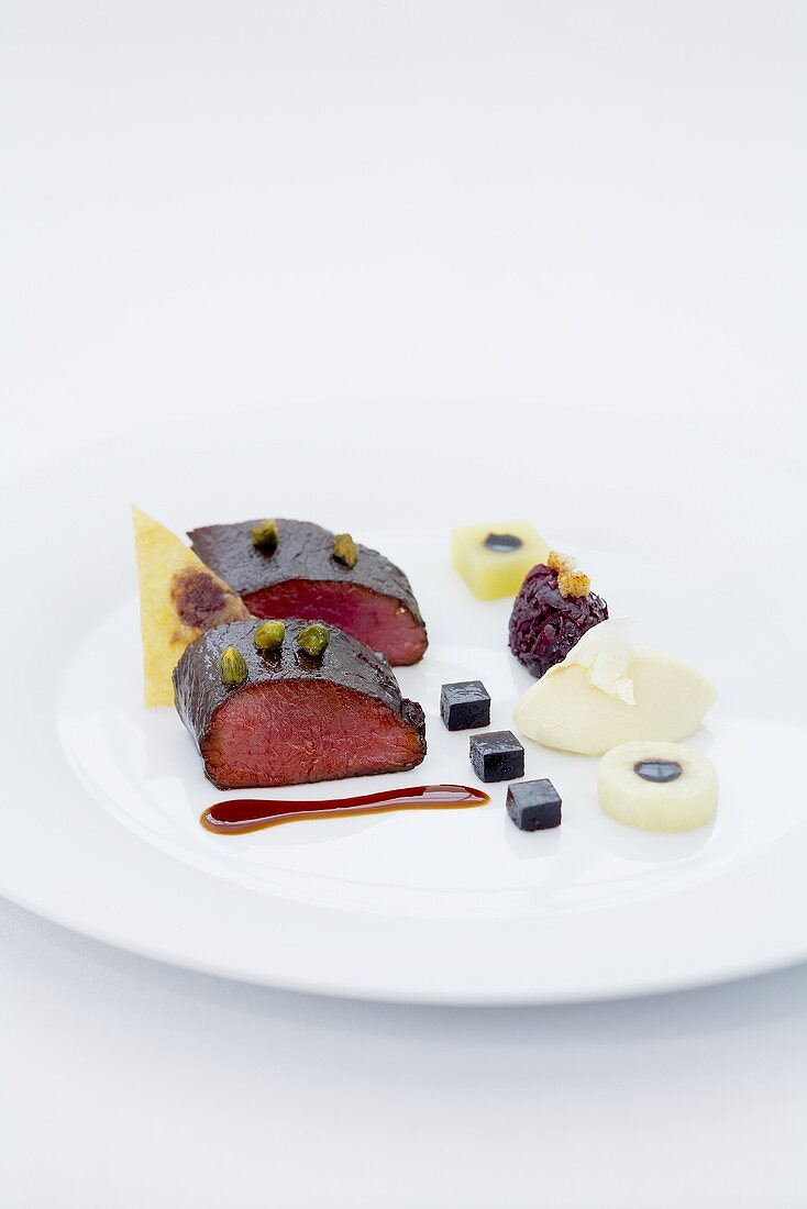 Braised saddle of venison with pistachios and caramelised red cabbage
