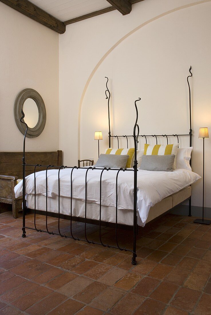 Iron bedstead with white bed linen in a Mediterranean country home