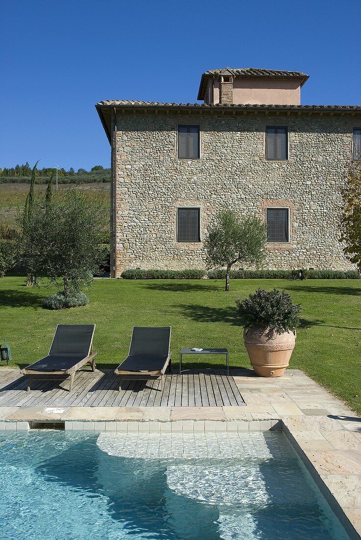 Pool with deckchairs in a garden of a Mediterranean country home