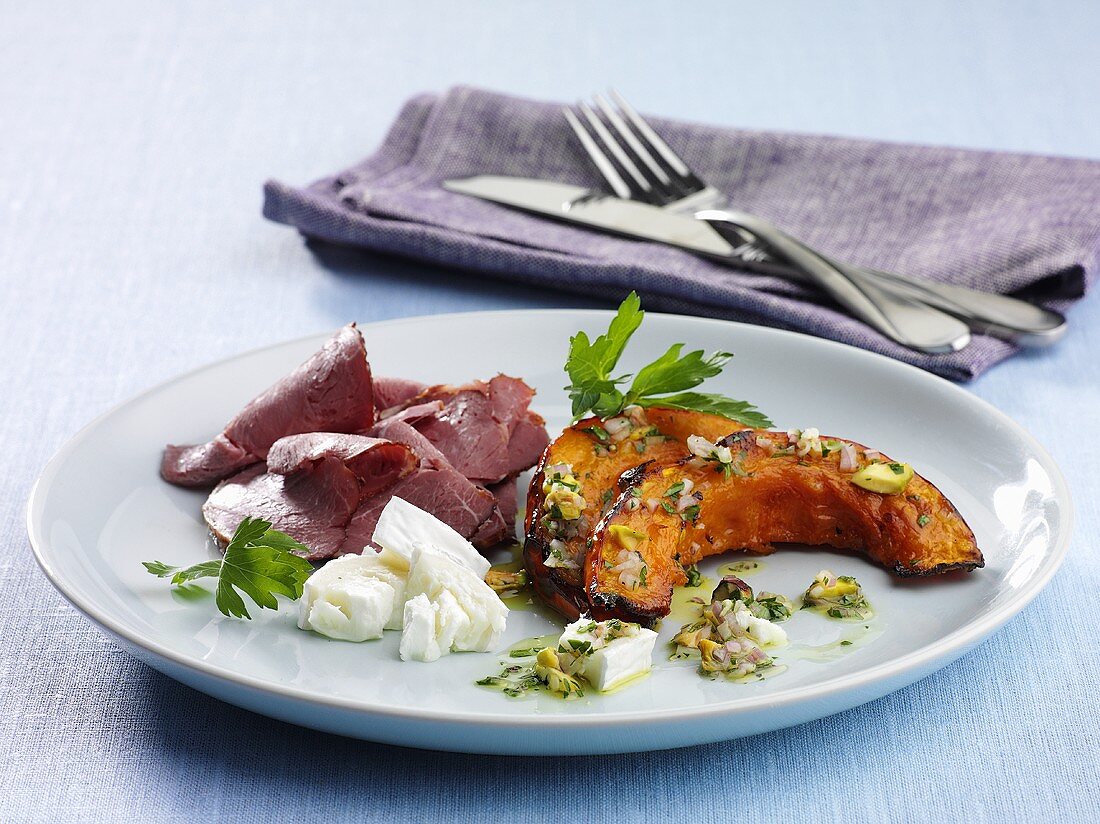 Baked pumpkin with a pistachio vinaigrette, goat's cheese and ham