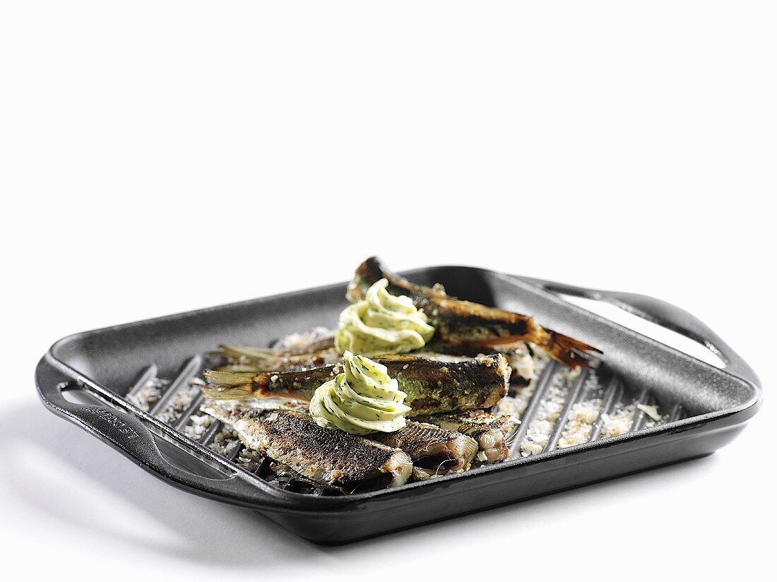 Baltic Sea herring with herb butter in a grill pan