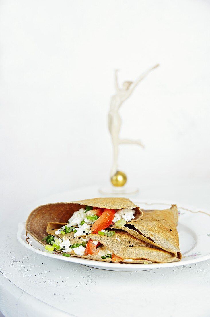Pancakes filled with feta, tomatoes and spring onions