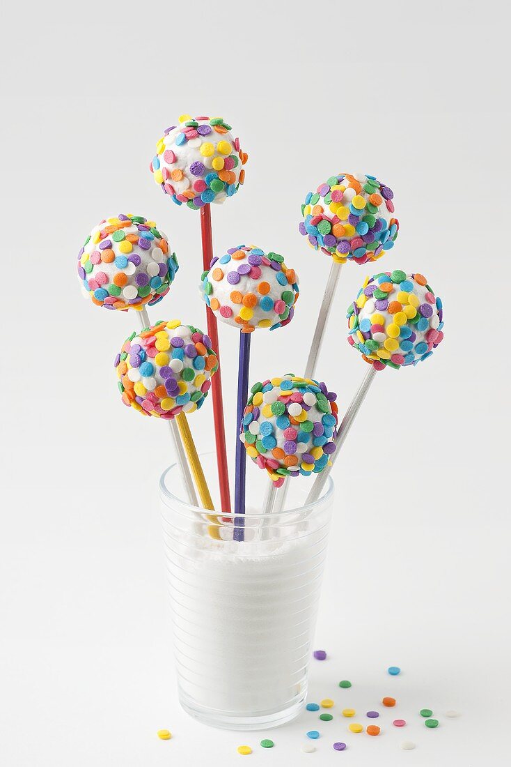 Cake pops with white icing and colourful sugar strands