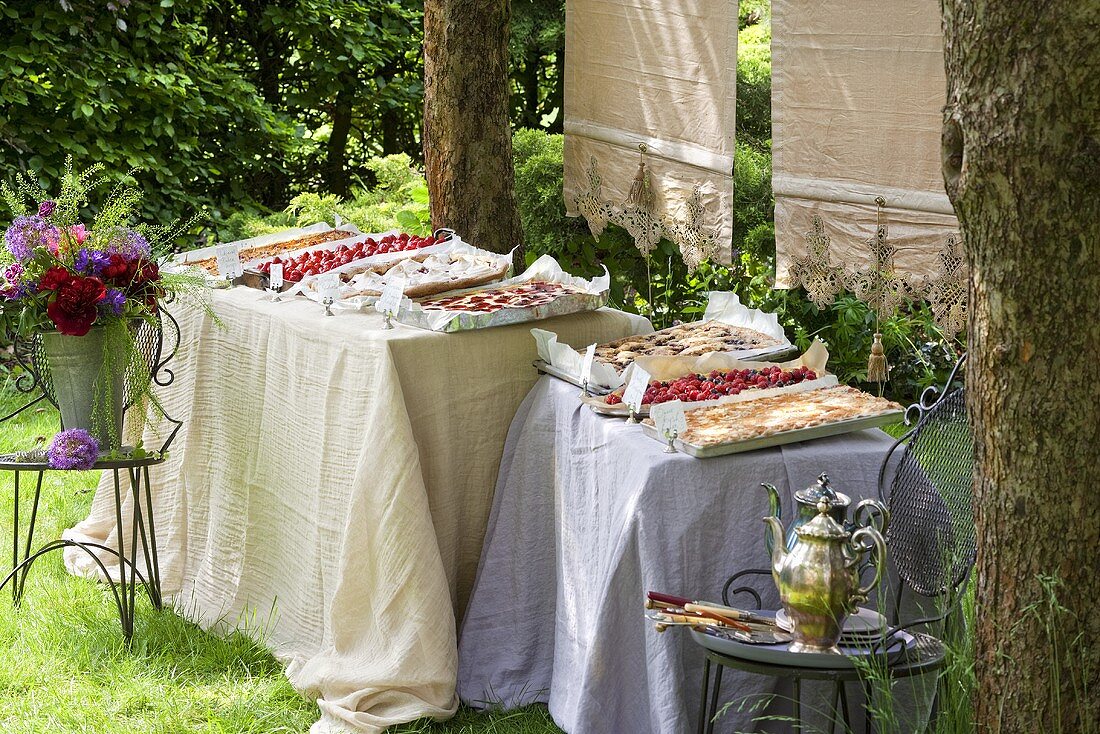 A cake buffet with tray bakes in a garden