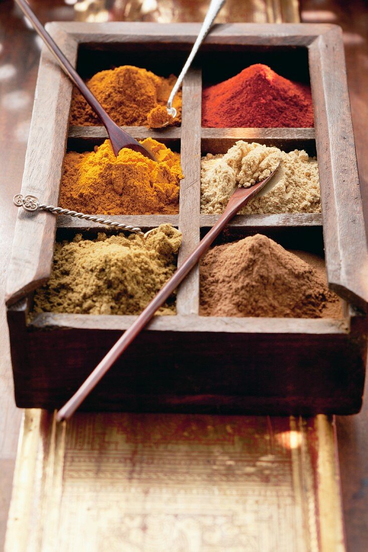 Various spices in a wooden box with spoons (Arabia)