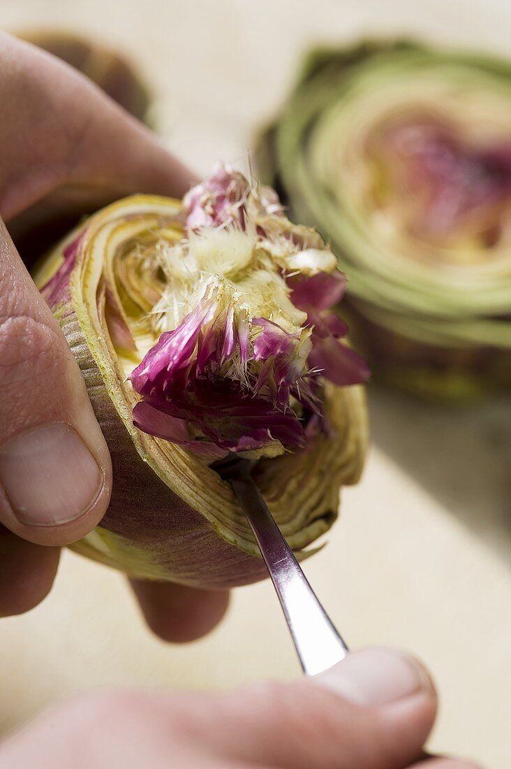An artichoke base being removed