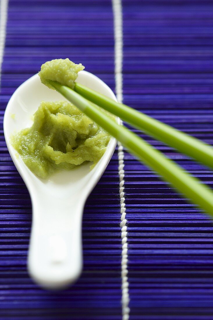 Wasabi paste on a porcelain spoon with chopsticks
