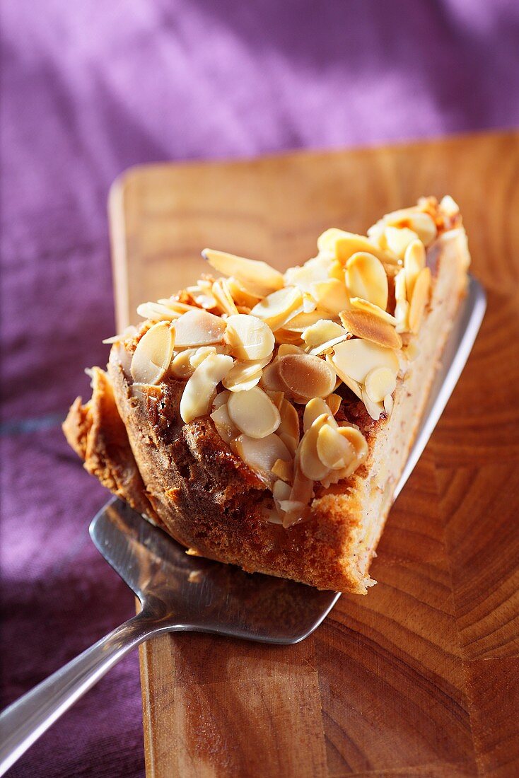 A slice of apple and yogurt cake with slivered almonds