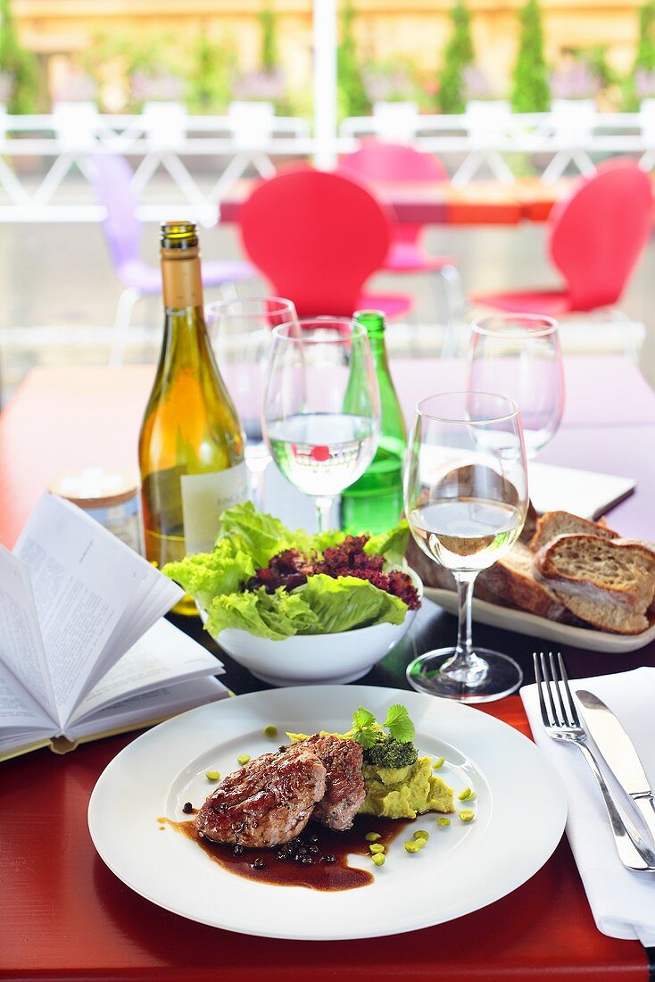 Pork fillet with pea puree, salad, bread and wine