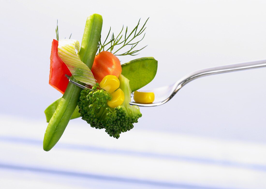 Cooked mixed vegetables on a fork