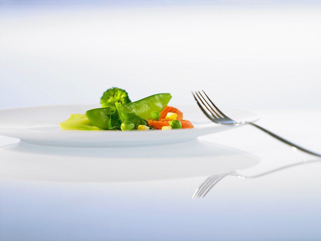 Mixed vegetables on a plate with a fork