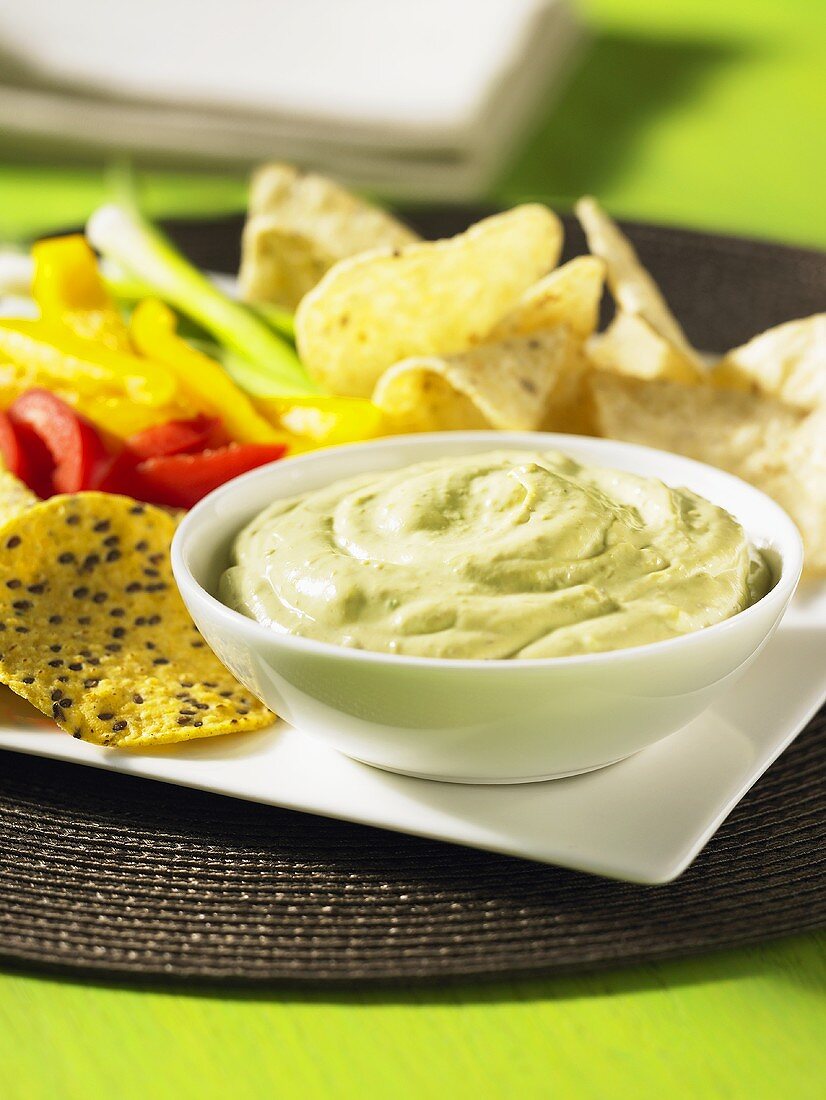 Avocado dip with crisps and fresh vegetables